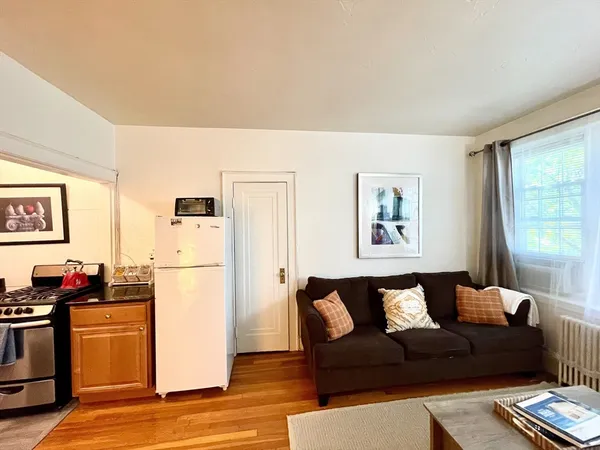 a living room with furniture fireplace and wooden floor