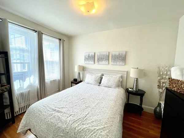 a large bed sitting in a bedroom next to a window