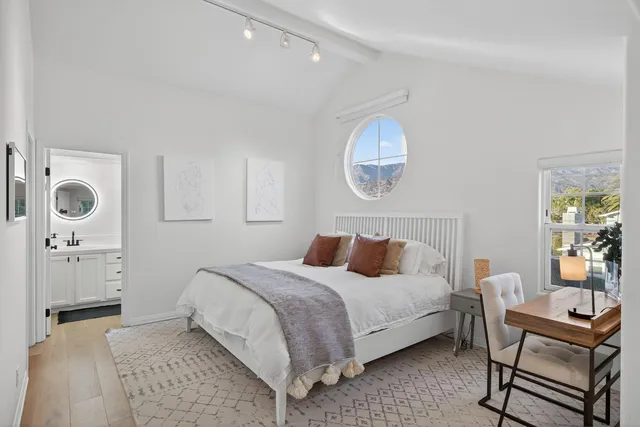 a bedroom with a bed and a chandelier