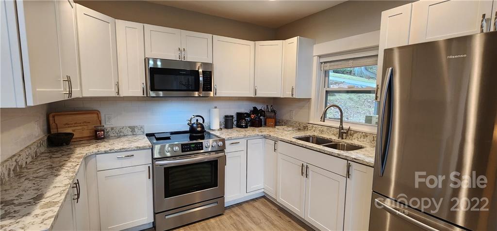 90 Ash Drive Maggie Valley, NC 28751 - Photo 7 of 27 a kitchen with a sink stove and refrigerator