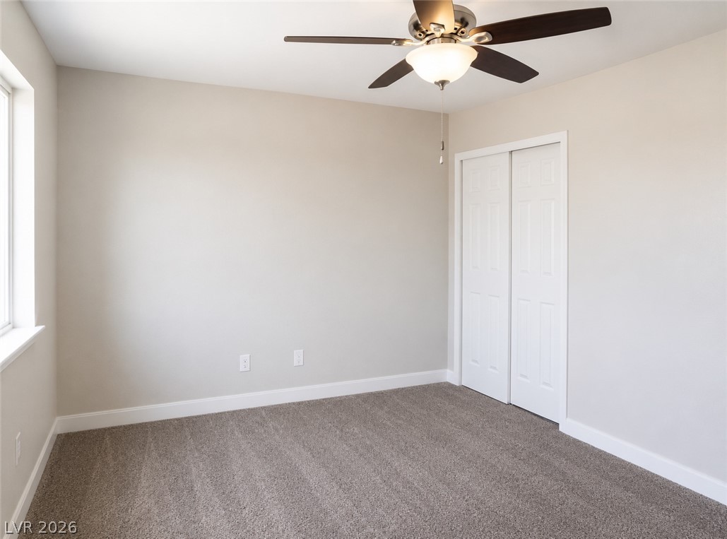 200 East Gamebird Road Pahrump, NV 89048 - Photo 16 of 23 A well-lit bedroom features plush carpeting and a convenient sliding door closet.