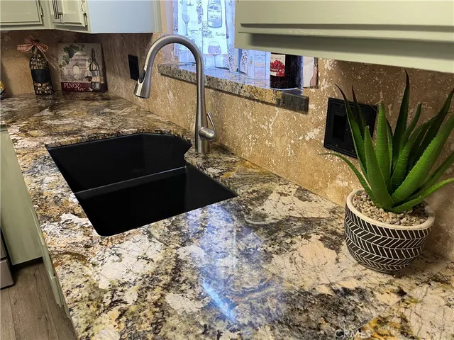 a kitchen with granite countertop a stove and a sink