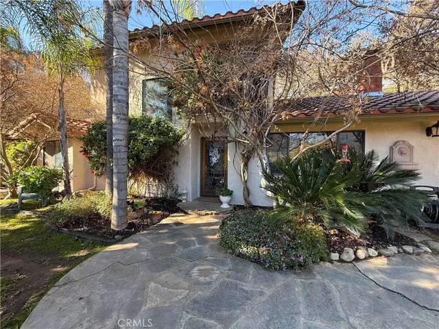 a couple of flower plants sitting in front of a house