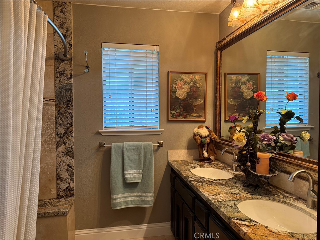 40820 Oak Ridge Drive Three Rivers, CA 93271 - Photo 28 of 65 a bathroom with a granite countertop sink a mirror and shower