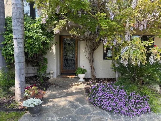 a front view of a house with a yard and flowers
