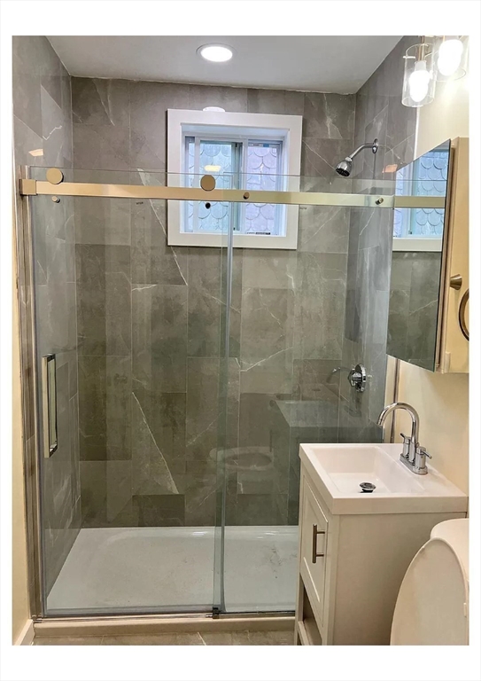 22 Anita Terrace, Unit 3 Boston, MA 02119 - Photo 4 of 11 a bathroom with a sink mirror and shower