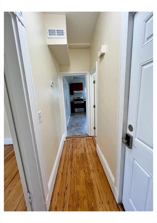22 Anita Terrace, Unit 3 Boston, MA 02119 - Photo 7 of 11 a view of a hallway view with wooden floor and staircase