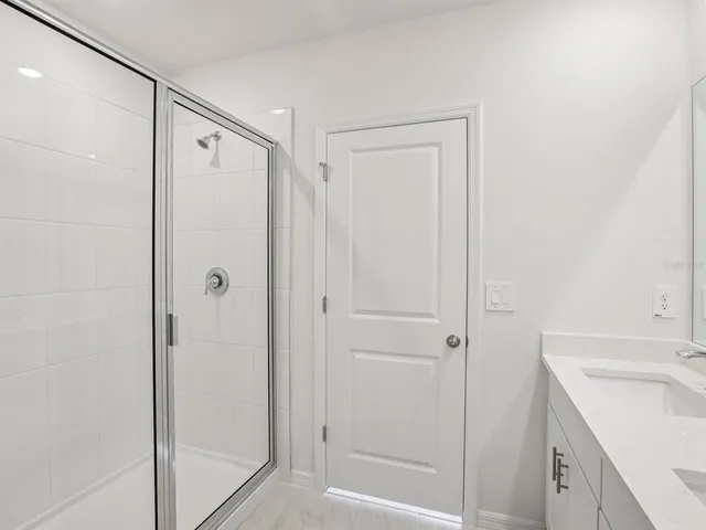 a bathroom with a shower sink and vanity