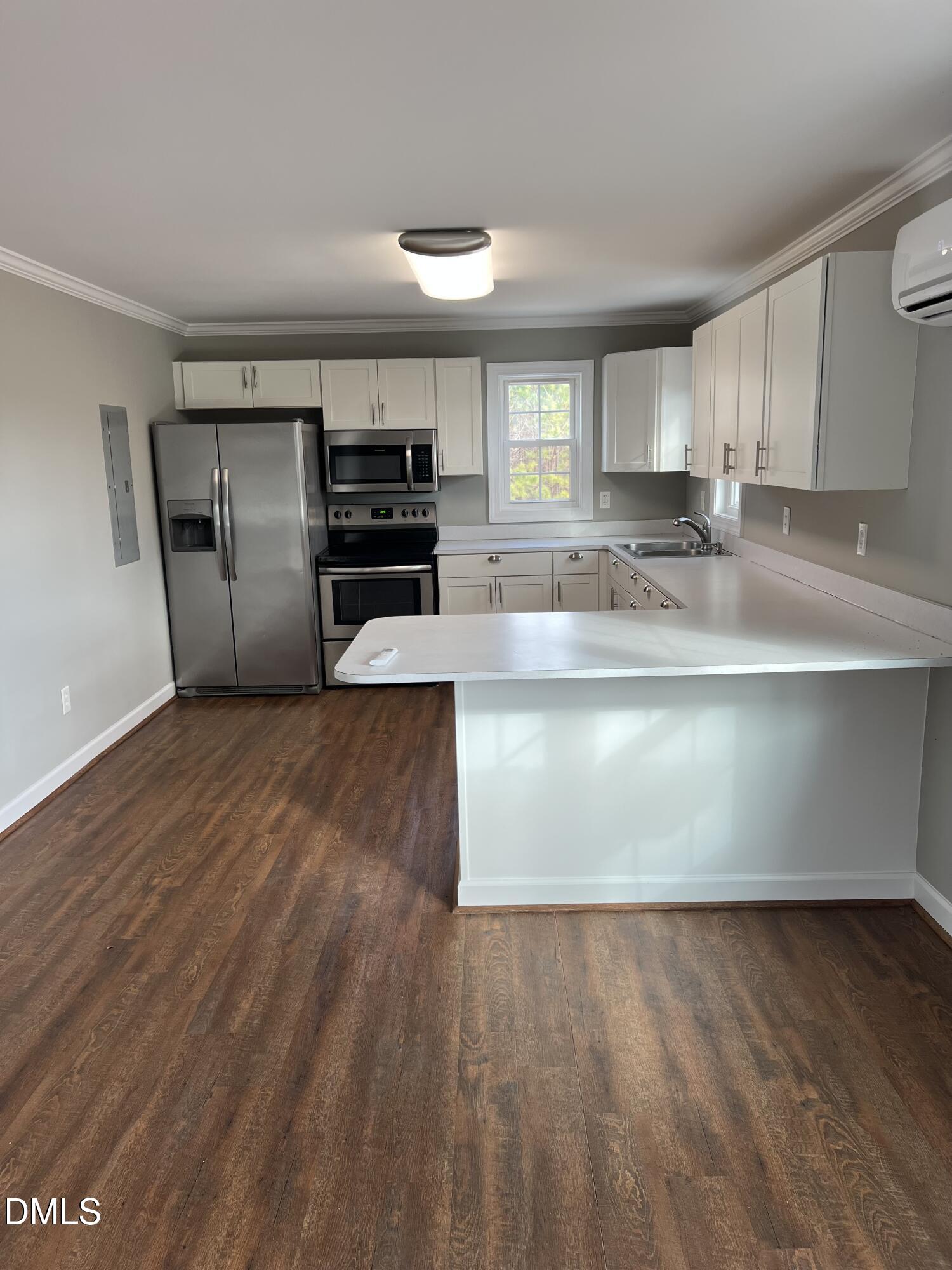 317 Brewer Road Louisburg, NC 27549 - Photo 6 of 14 a large kitchen with kitchen island a sink dishwasher a stove and a refrigerator with wooden floor