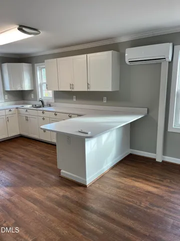 a kitchen with a sink cabinets and wooden floor