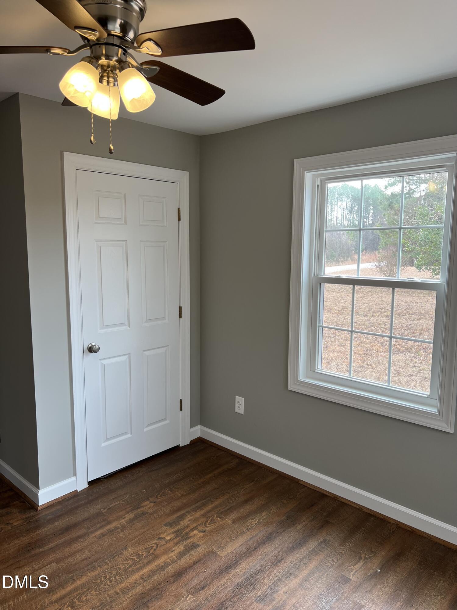 317 Brewer Road Louisburg, NC 27549 - Photo 9 of 14 a view of an empty room with window and wooden floor