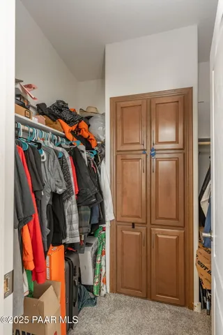 a view of walk in closet with clothes and shoes