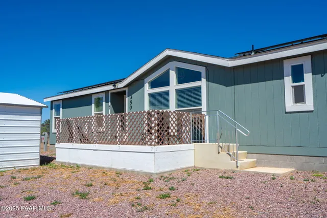 a view of wooden house and a yard