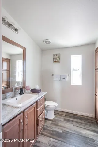 a bathroom with a granite countertop sink a toilet and a mirror