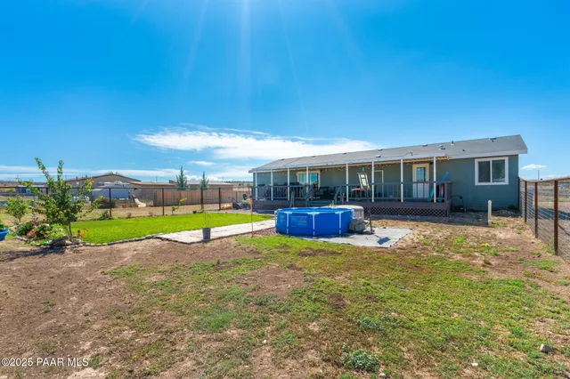 a view of backyard with swimming pool and seating