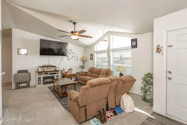 a living room with furniture a flat screen tv and a large window