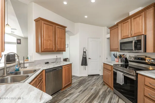 a kitchen with stainless steel appliances granite countertop a sink stove and microwave