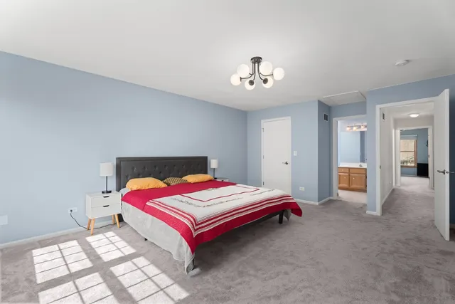 a bedroom with a bed and a chandelier