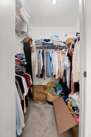 a view of walk in closet with clothes and shoes