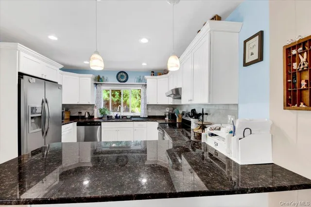 a large white kitchen with lots of counter space and refrigerator