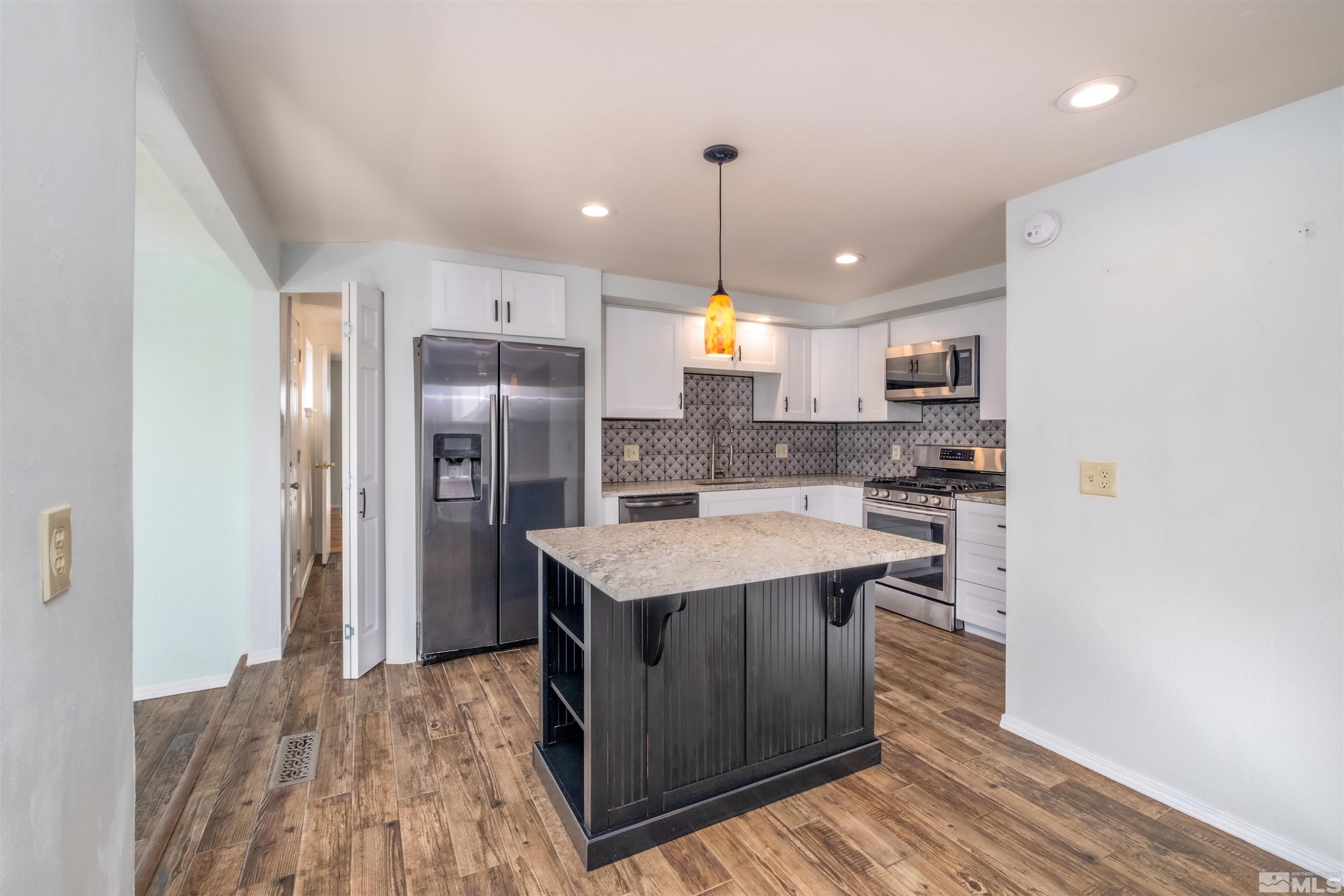 1800 West 6th Street Reno, NV 89503 - Photo 18 of 23 a kitchen with stainless steel appliances granite countertop a sink a stove and a refrigerator