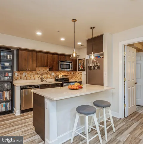 a kitchen with stainless steel appliances kitchen island granite countertop a sink and cabinets