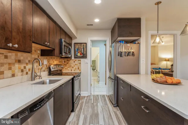 a kitchen with stainless steel appliances a sink stove and refrigerator