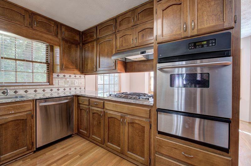 260 Spring Ridge Drive Roswell, GA 30076 - Photo 15 of 52 a kitchen with stainless steel appliances granite countertop a refrigerator a sink and wooden cabinets