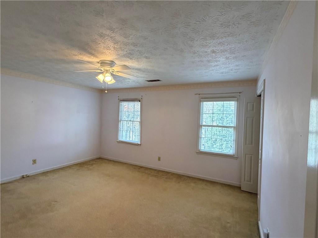 260 Spring Ridge Drive Roswell, GA 30076 - Photo 30 of 52 an empty room with windows and chandelier fan