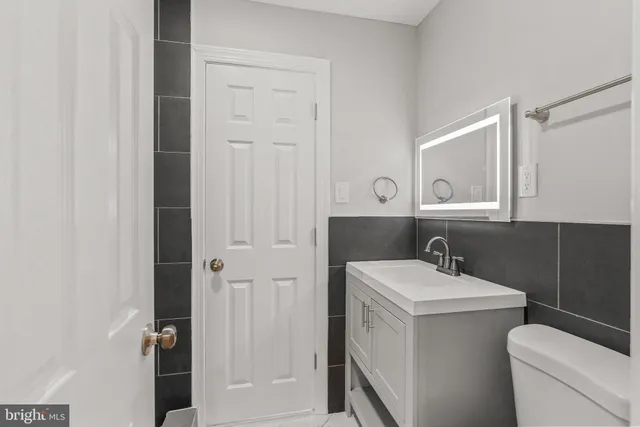 a bathroom with a sink a toilet and a mirror