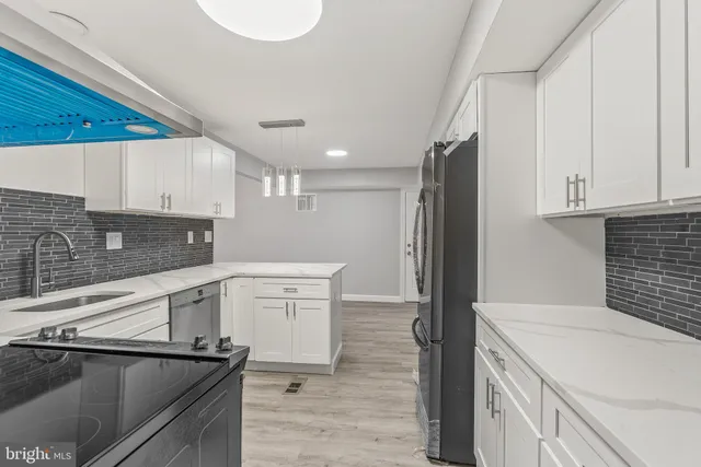 a kitchen with a sink cabinets and wooden floor