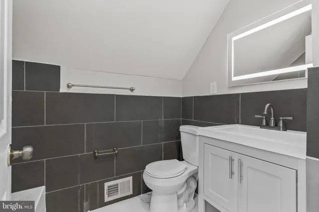 a bathroom with a sink toilet and a mirror