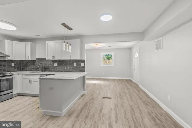 a kitchen with wooden floors white cabinets and sink