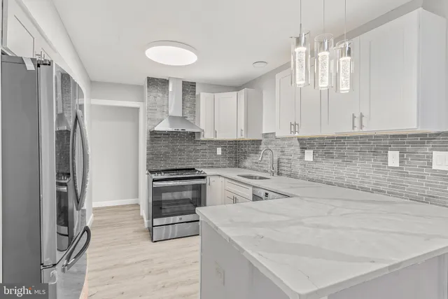 a kitchen with stainless steel appliances white cabinets and a refrigerator