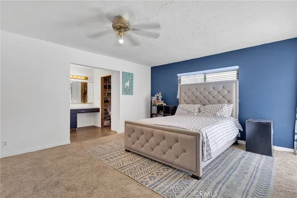 a bedroom with a large bed and a chandelier