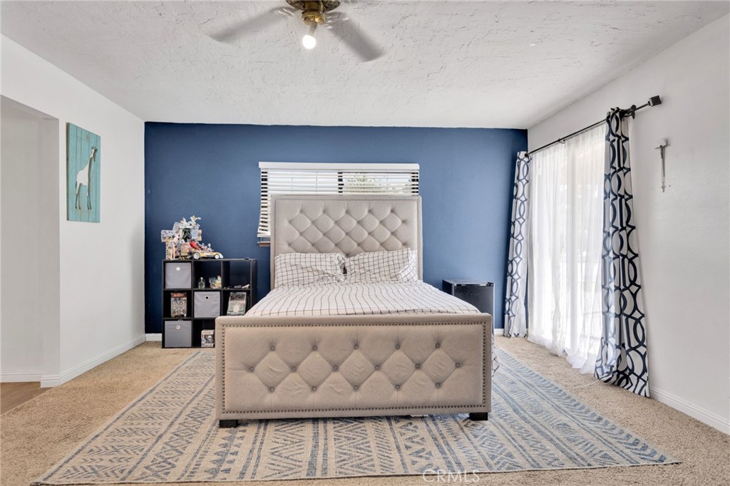 20357 Ituma Road Apple Valley, CA 92308 - Photo 14 of 38 a bedroom with a bed and a chandelier