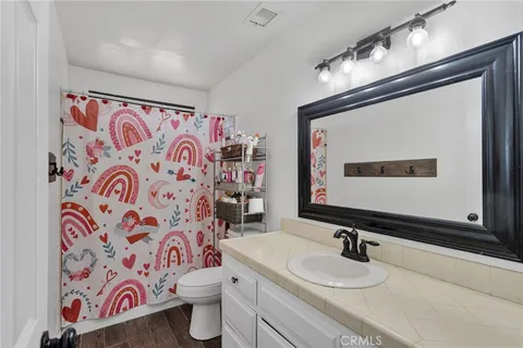 a bathroom with a sink mirror vanity and toilet