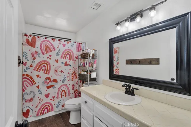 a bathroom with a sink mirror vanity and toilet