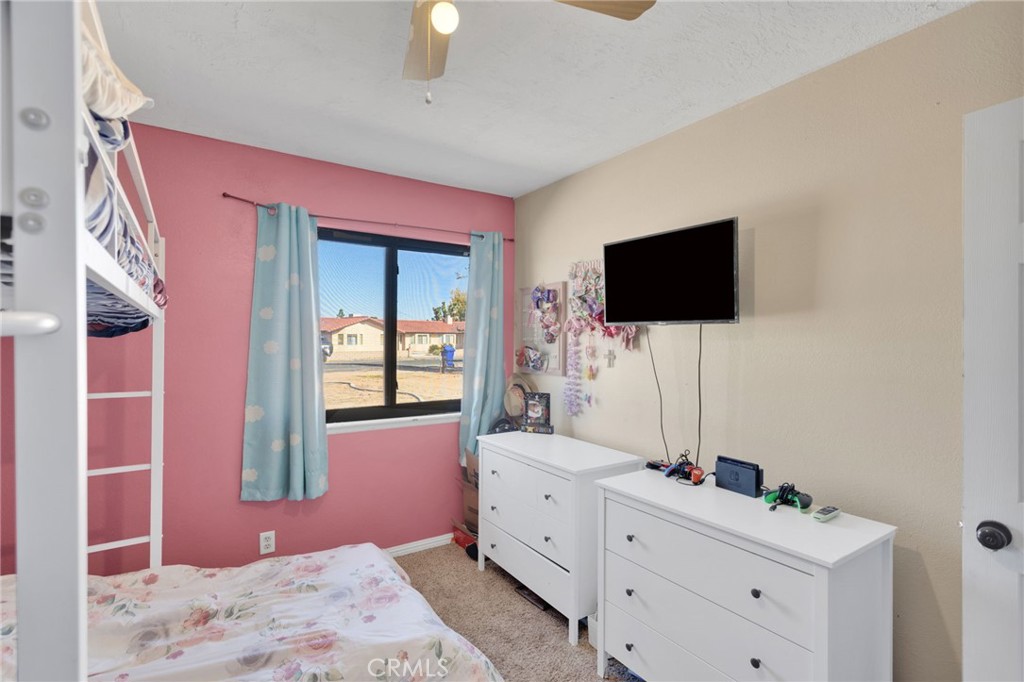 20357 Ituma Road Apple Valley, CA 92308 - Photo 22 of 38 a bedroom with a bed and a flat screen tv
