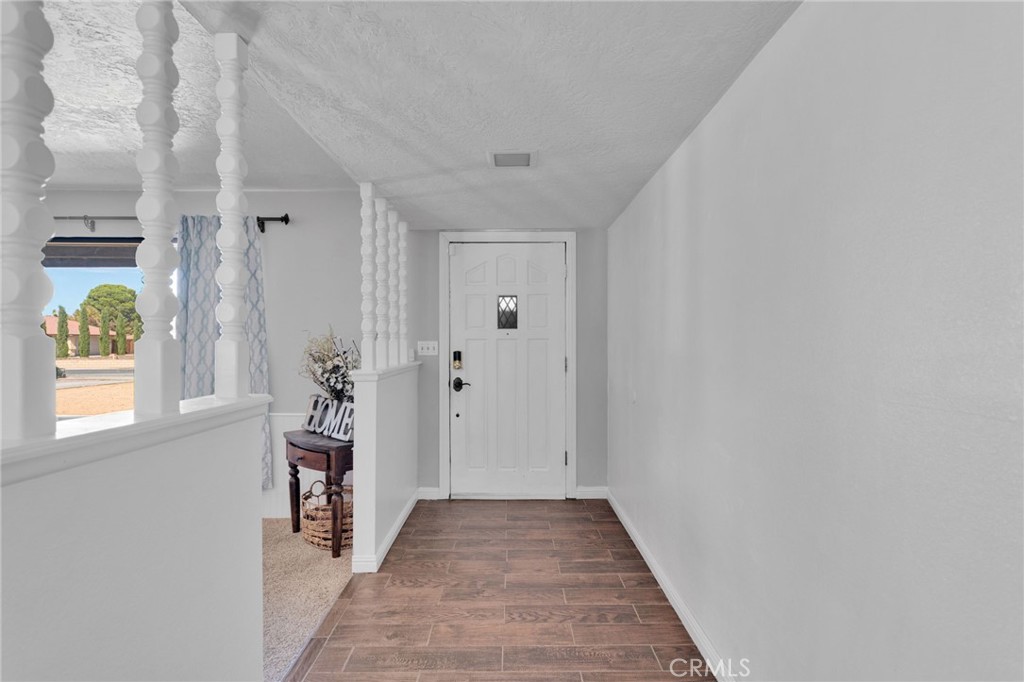 20357 Ituma Road Apple Valley, CA 92308 - Photo 28 of 38 a view of a hallway with wooden floor and a window