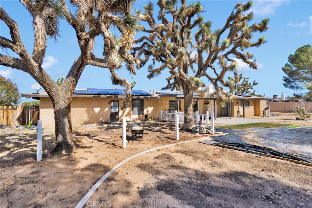 20357 Ituma Road Apple Valley, CA 92308 - Photo 32 of 38 a view of a backyard with a table and chairs under a large tree
