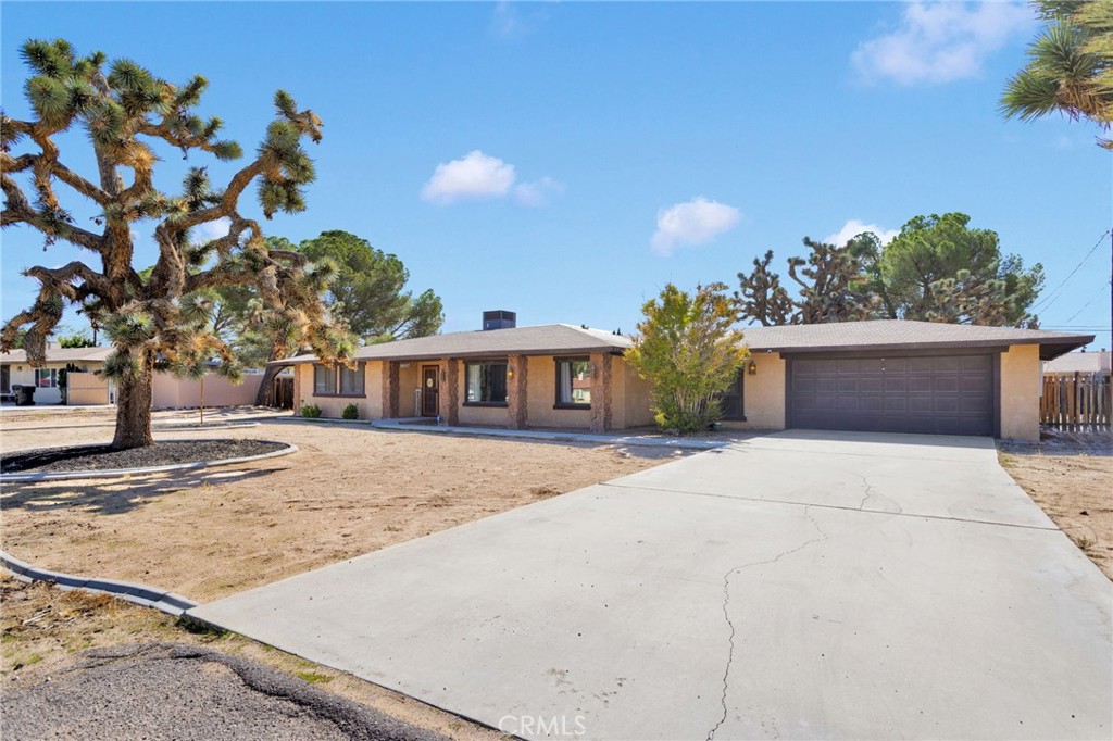 20357 Ituma Road Apple Valley, CA 92308 - Photo 37 of 38 a front view of a house with a yard and a garage