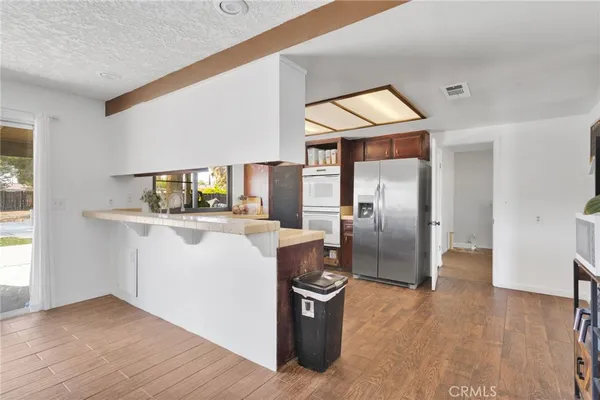 a kitchen with stainless steel appliances granite countertop a refrigerator and a stove