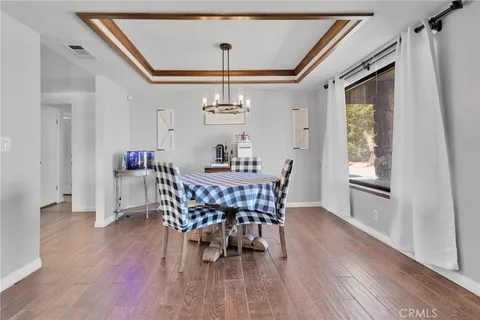 a dining room with furniture a chandelier and wooden floor