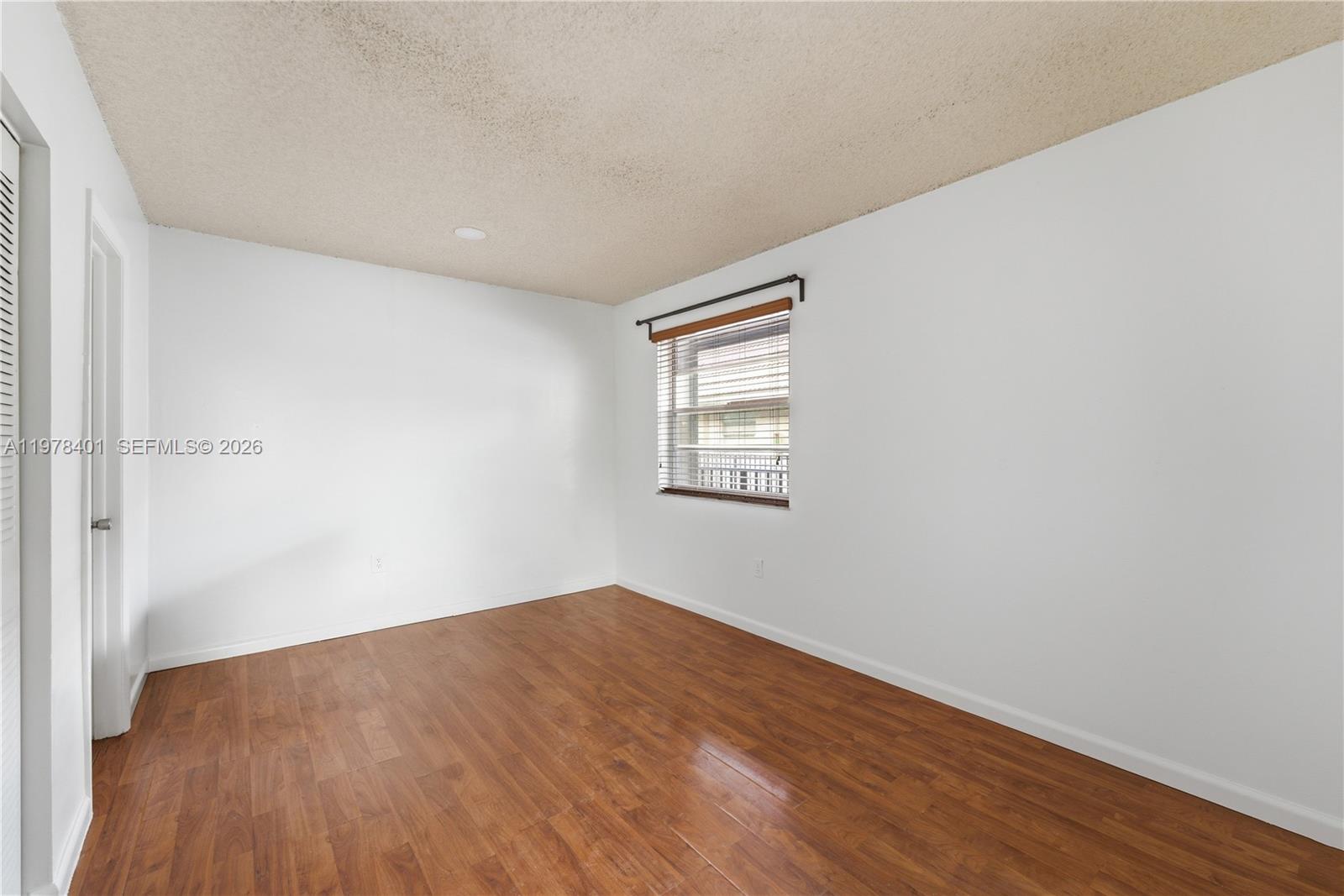 6921 Southwest 129th Avenue, Unit 5 Miami, FL 33183 - Photo 17 of 34 an empty room with wooden floor and windows