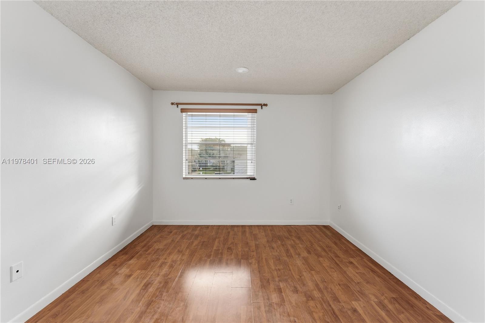 6921 Southwest 129th Avenue, Unit 5 Miami, FL 33183 - Photo 10 of 34 an empty room with wooden floor and windows