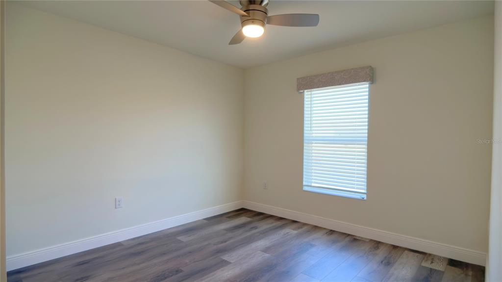 13574 Southwest 47th Circle Ocala, FL 34473 - Photo 19 of 25 an empty room with wooden floor fan and windows