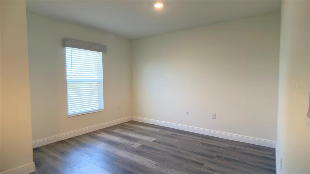 13574 Southwest 47th Circle Ocala, FL 34473 - Photo 20 of 25 an empty room with wooden floor and windows