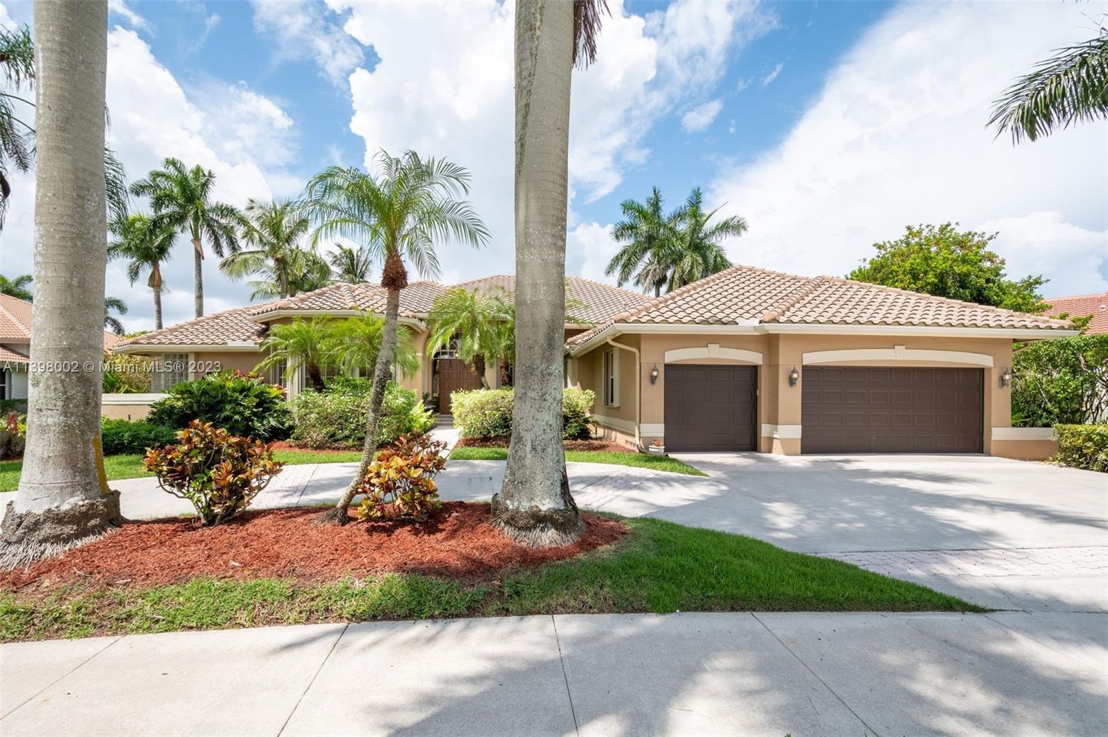 3155 Inverness Weston, FL 33332 - Photo 2 of 58 a front view of a house with a yard and potted plants