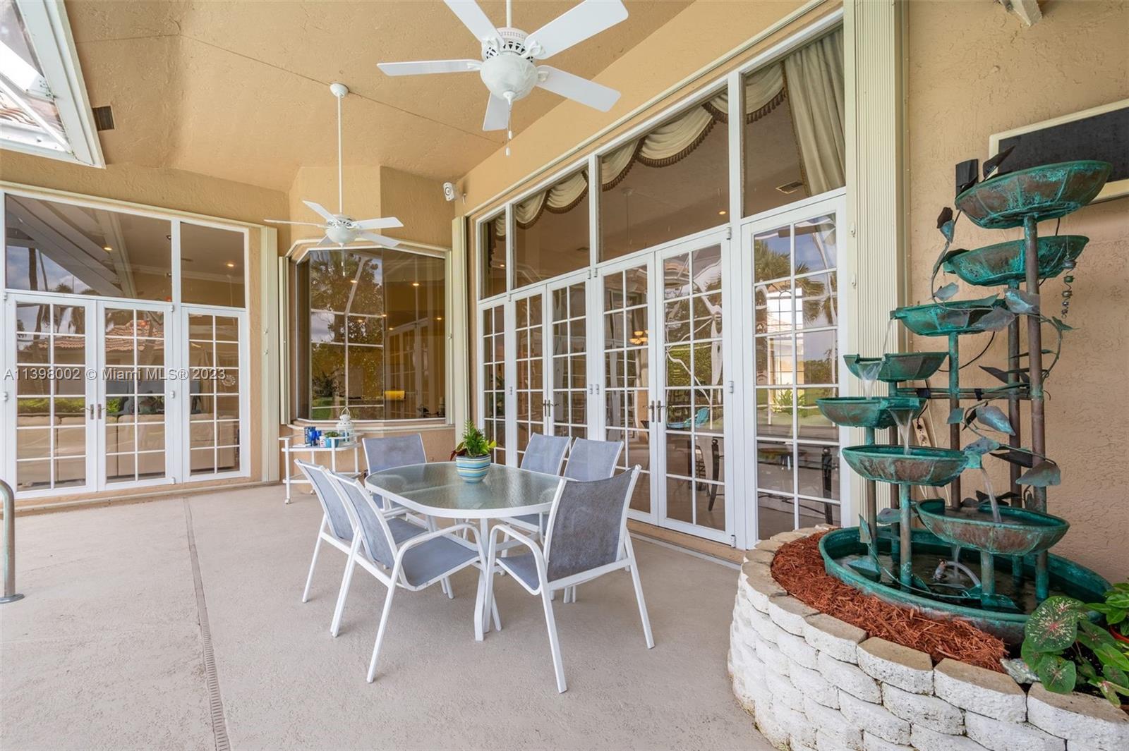 3155 Inverness Weston, FL 33332 - Photo 26 of 58 a patio with a table and chairs and potted plants
